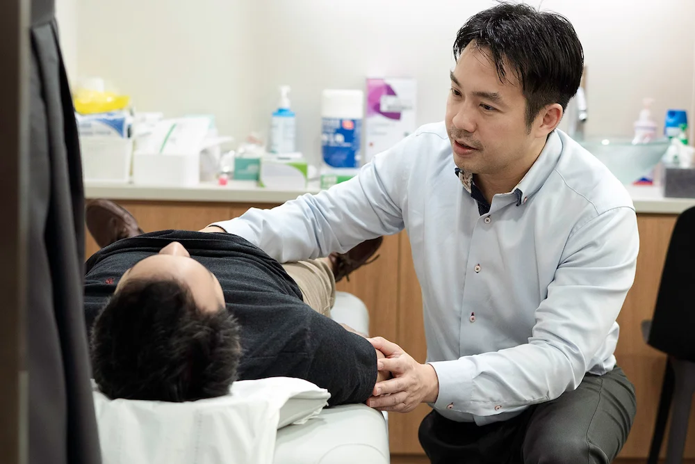 唐永贤医生正在为病人检查的图片